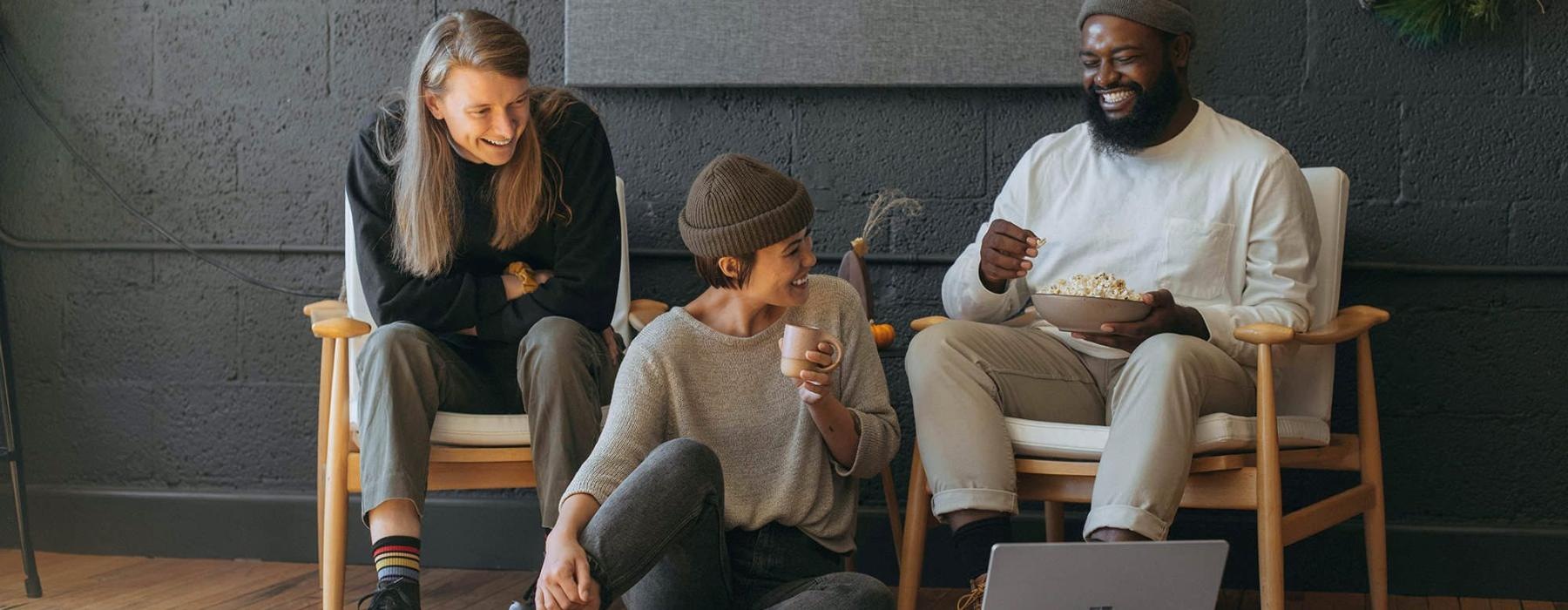 friends sit together around an open laptop